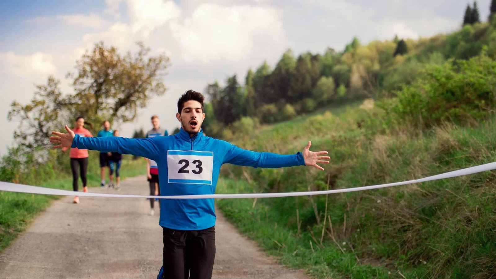Man runner crossing finish line in a race competition in nature